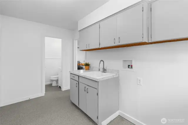 UTILITY BATHROOM | This tucked away bathroom features a toilet and sink. Located as you come into the home from the garage on the left. There is a door from the laundry room to the kitchen so you can close it for privacy.