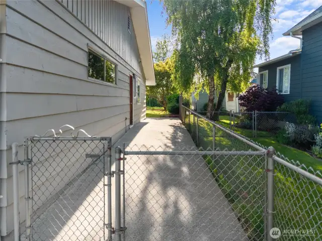 RIGHT SIDE OF THE HOME | This wide concrete sidewalk rolls down the right side of the home from the front around the corner to the back patio.