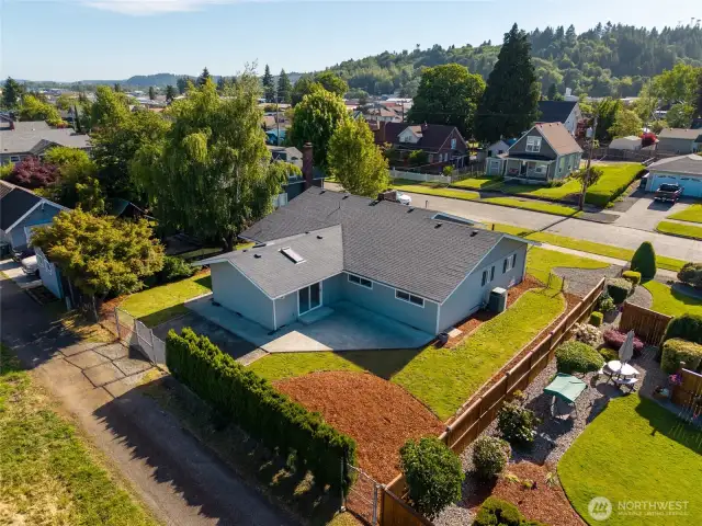 An aerial view of this gorgeous home from the back shows off the size of the backyard and patio as well as the alley behind the home that gives additional access to the property.