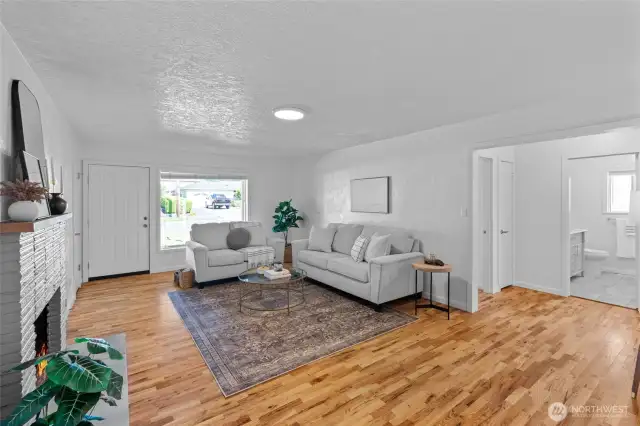 LIVING ROOM | Enter the home into a perfect living space with hardwood floors, brick fireplace, and fresh paint.