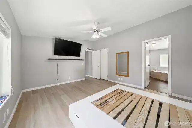 Primary bedroom with bed frame and TV that both stay.
