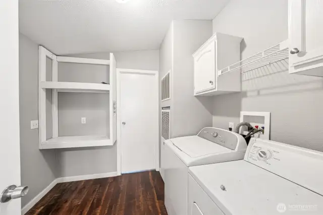 Utility room with cabinets and shelves.