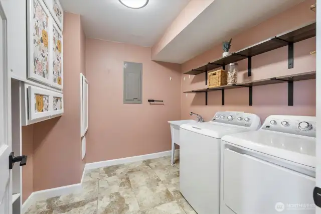 Large laundry area with convenient utility sink and plenty of storage space.