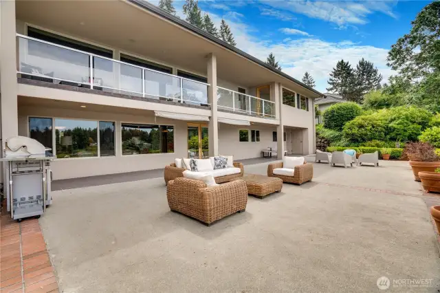 Rear facade of the home with spacious patio & covered deck.  Gas grill hookup and storage rooms under upper deck on both ends of the home.