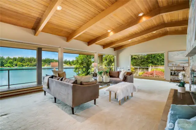 Fabulous interior in the main level great room with vaulted wood ceilings & wrap around windows to enjoy the view.