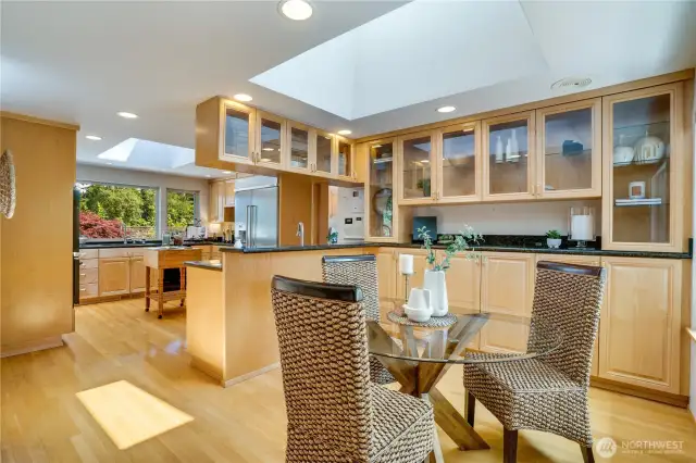Casual dining off the kitchen in the nook with glass door cabinets for display.
