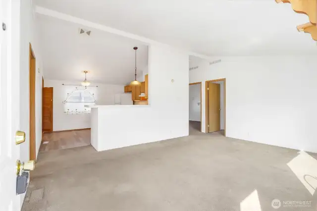 As you walk in the door into the living room you see the kitchen in the background.