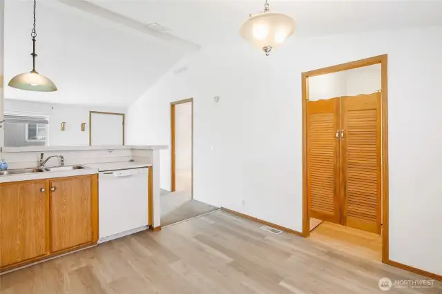 Another view of the kitchen, vaulted ceiling in the living room, and the doors to the utility room.