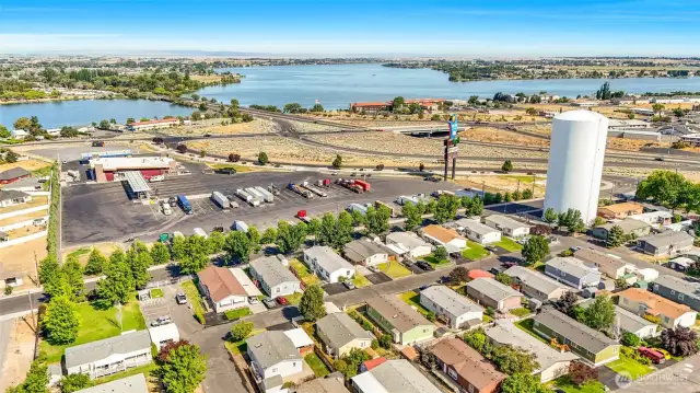 You're looking in the middle row of homes, 2nd home from the left, with the large tree in front.  Close to the lake, shopping, fuel, and the freeway!