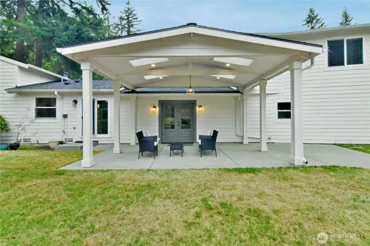 Gather in comfort—covered backyard space with skylights perfect for any weather.