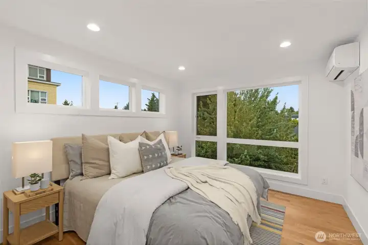 Primary suite retreat with expansive windows bringing in morning light and views.