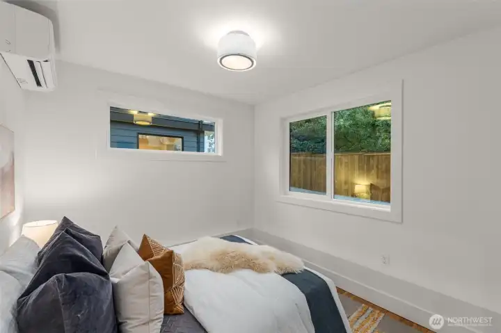 Comfortable guest bedroom with natural light and airy finishes.