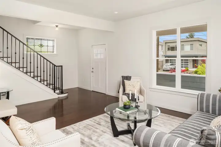 The open concept floor plan and tall ceiling makes the entry and living room inviting, airy, and bright.
