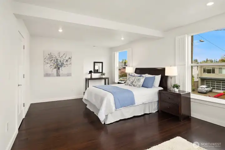 The large, East-facing primary bedroom bring in great morning light, with en suite bathroom and walk-in closet.