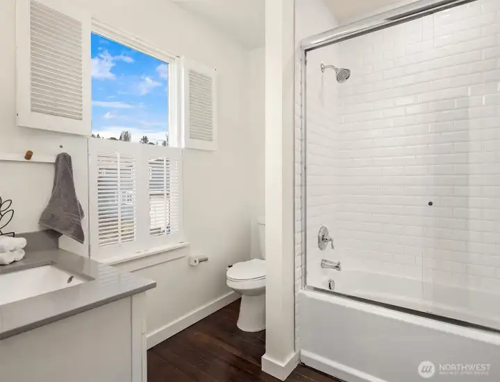 Second floor full/guest bathroom with Quartz counters and tile tub/shower.