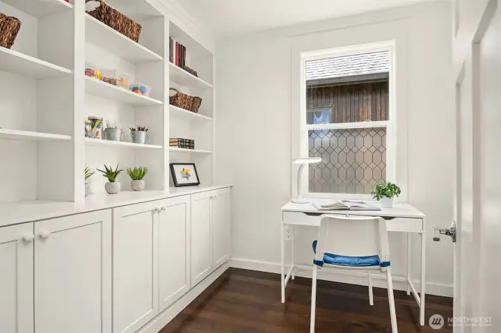 An office with built-in cabinets and shelves complete the second floor.