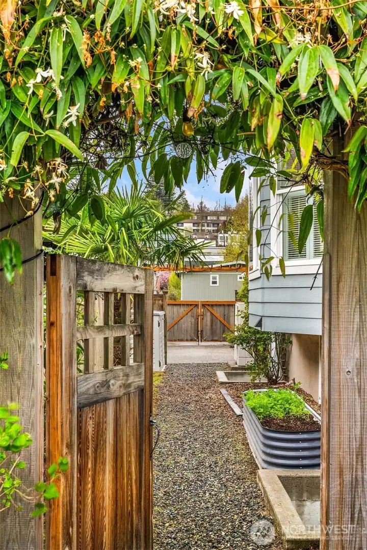Large, fenced-in backyard with flagstone patio, shed, and lush landscaping offers a private urban oasis.