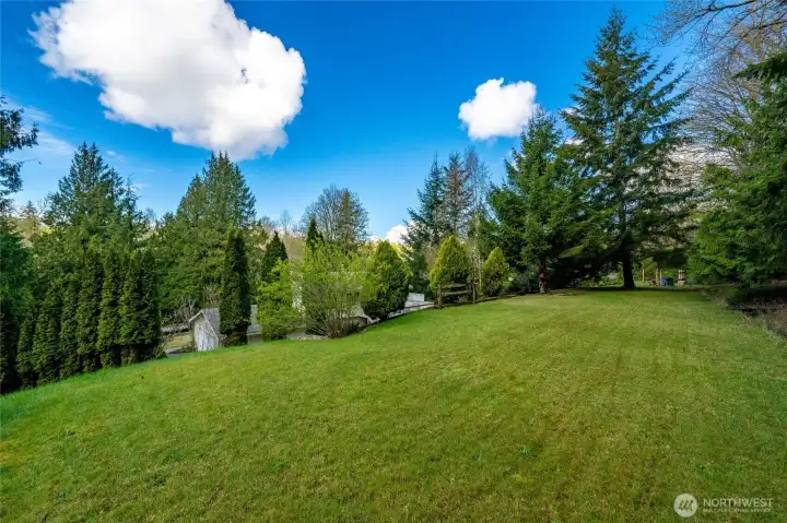 The upper flat sunny backyard, perfect for playing games and enjoying the surrounding views.