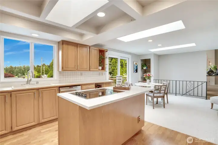 This kitchen has the cooktop and preparation island at its heart and the skylights bathe the space in light.  Use the adjoining room for family room, informal dining, reading nook, homework station - you choose.