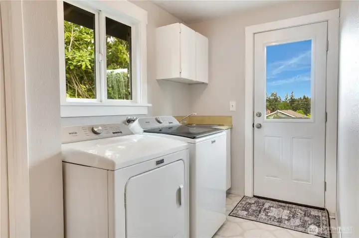 This main floor laundry room has a closet for storage, cabinets, a deep sink, and a door to outside.  When you've been working in the yard, this mudroom allows you to keep the mess contained.