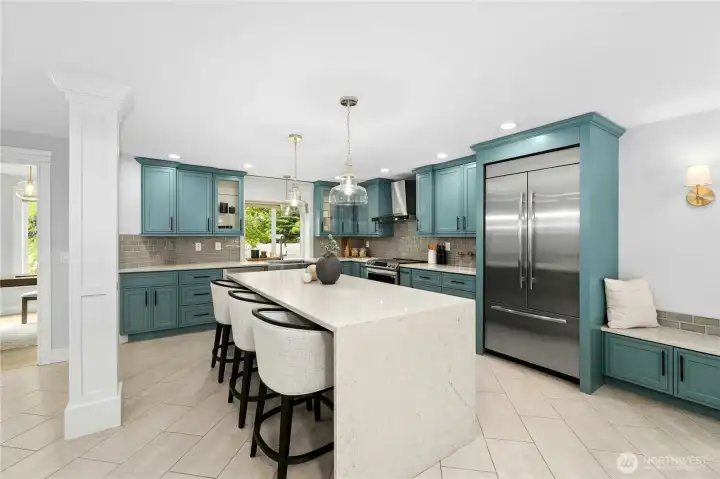 Spacious kitchen with upgraded appliances and seated granite waterfall island