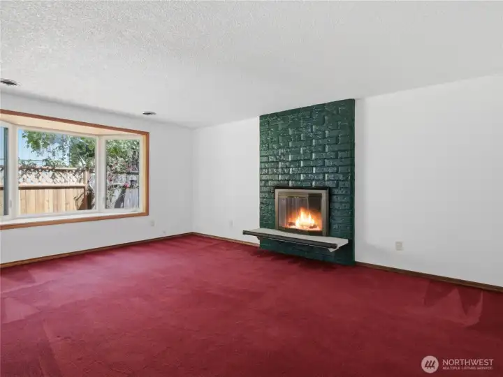 Cozy wood burning fireplace with window seat nook.
