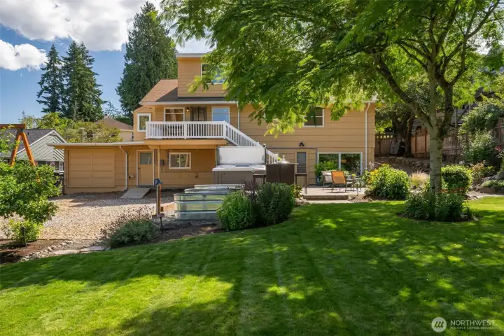 View of the back of the home showcasing gardening boxes, hot tub, and entertaining spaces. View of the back of the home showcasing gardening boxes, hot tub, and entertaining spaces.