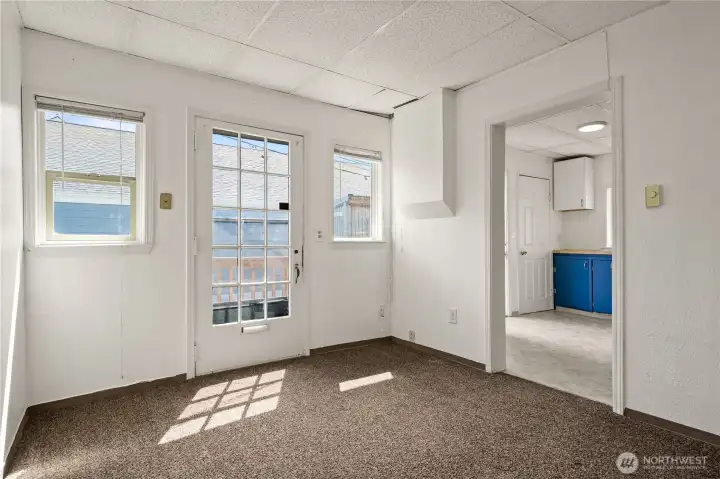 Living area in the second unit with private exterior access and adjoining kitchen.
