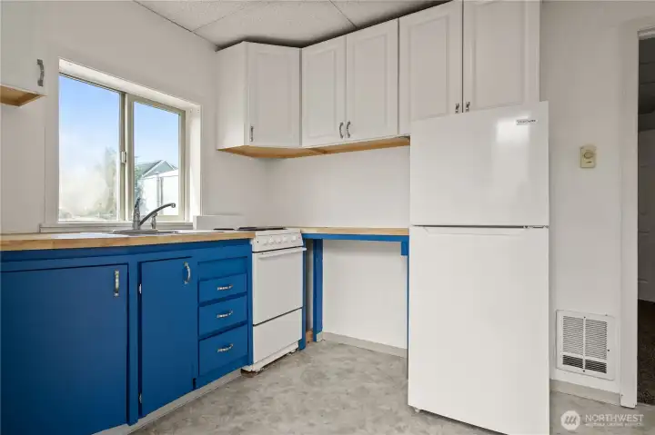 Updated kitchen in the second unit featuring ample cabinetry, full-size appliances, and natural light.