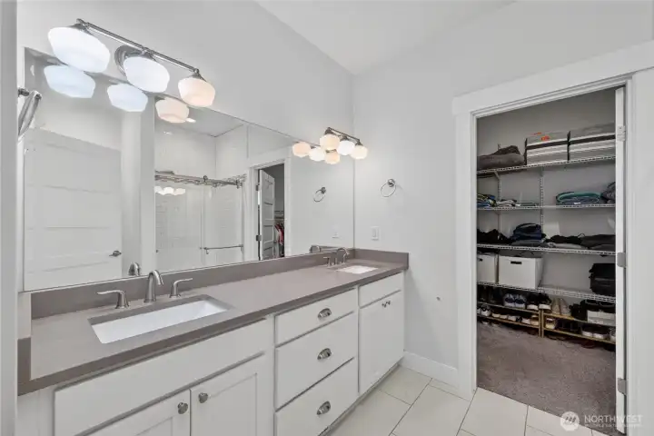 Double vanity, undermount sinks, tile flooring in primary ensuite.