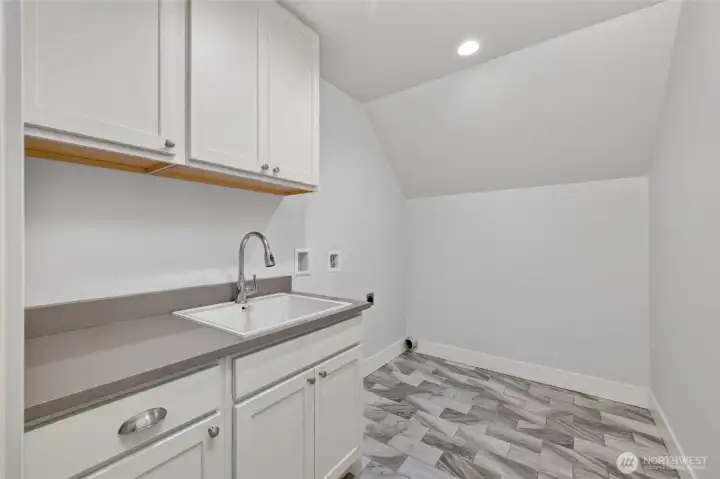Upper level laundry with extra storage and utility sink.