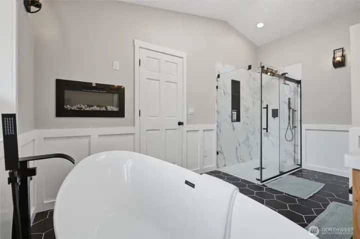 Soaking tub overlooking back yard with electric fireplace