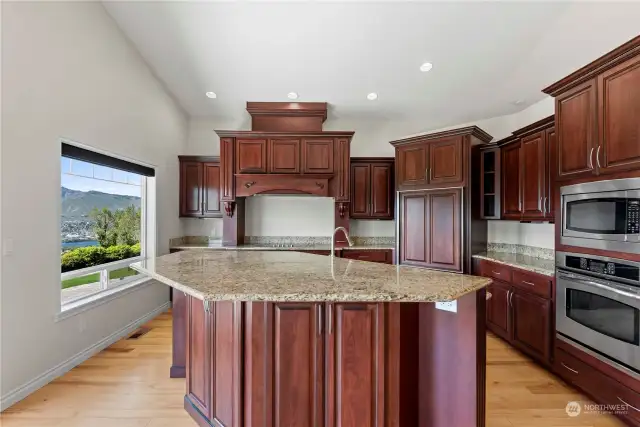 Kitchen w/ custom cabinets, under cabinet lighting and granite slab countertops.