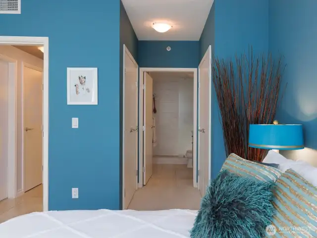 From primary bedroom leading to bathroom, two large closets with custom closet system on either side of hall.