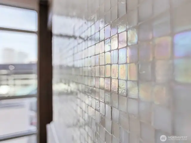 Ann Sacks Opalescent Mosaic Tumbled Tile meticulously installed one by one on the gas fireplace.