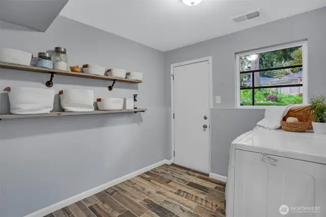 A well-functioning laundry/mudroom area with convenient access door to the backyard.