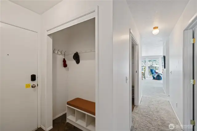 As you enter, there is ample coat closet and shoe storage on the left.  The full bathroom is on the right as you enter this bright, light happy home. Ther first door on the right is the Primary Bedroom.  The open pocket door on the left is the Utility Room.