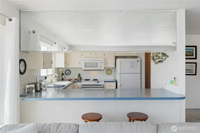 Kitchen with water views, room to sit and eat at the bar.  Clean, white and bright!