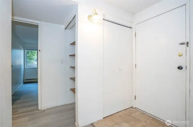 Welcoming entryway with a convenient closet and nearby shelving for added storage.
