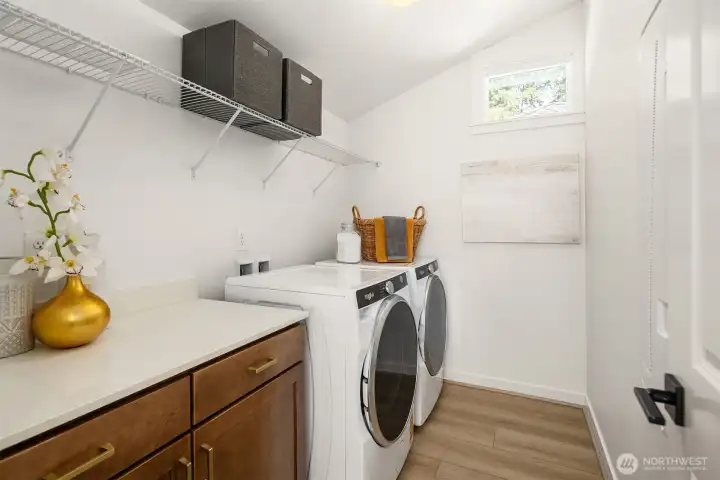 Cabinet for storage and folding in upstairs laundry room. Full appliance package including washer, dryer and refrigerator are included in this home.