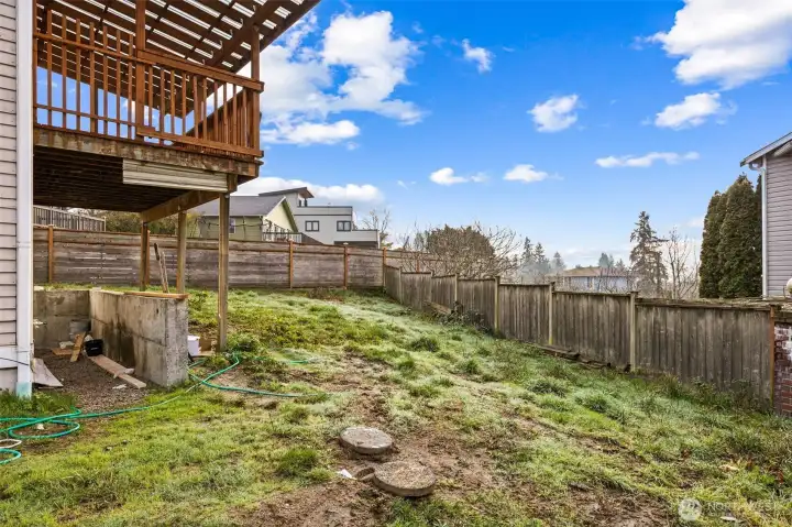 Backyard is partially fenced and is a blank slate for you to create your garden or zen area.