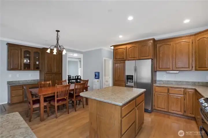 kitchen with desk area and small hallway to the half bathroom, pantry, laundry/mud room to garage