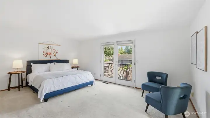 The upper level primary suite offers a balcony overlooking the back yard.