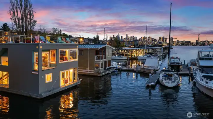 A profile view of the home at dusk, with downtown Seattle and the Space Needle glowing in the background.