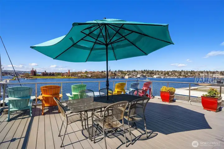 The rooftop deck: colorful Adirondack chairs, room for a large dining table, irrigated planters, and Gas Works Park directly across the water.