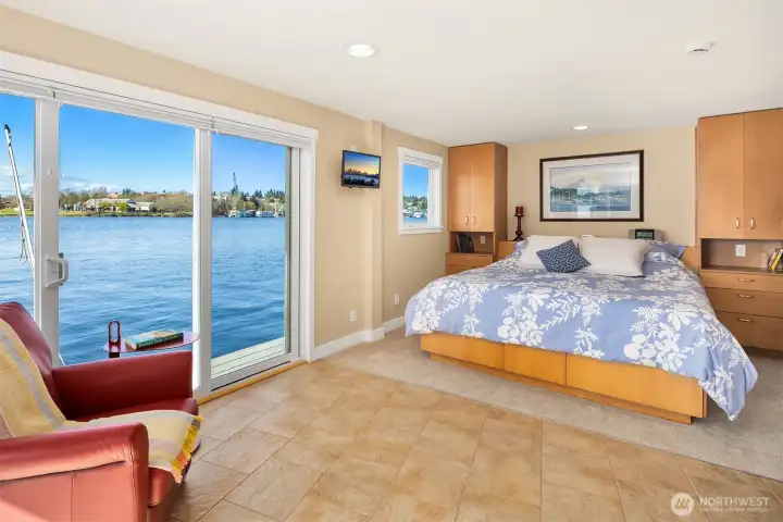 From another angle: the primary suite looks directly over open water, sliders wide enough to let the lake into the room.