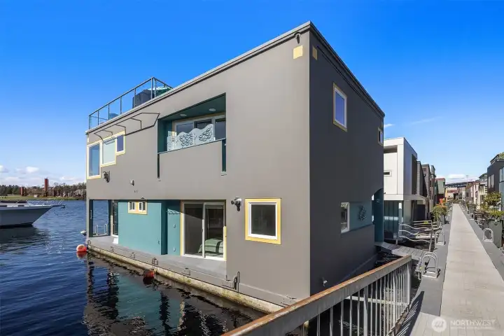 The side and water elevation show the home's three levels — entry, main living, rooftop — and the slip that runs its full length.
