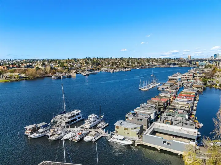 Looking toward the I-5 bridge, with the home anchored on the front row — a reminder that this is an end-of-dock, water-on-three-sides address.