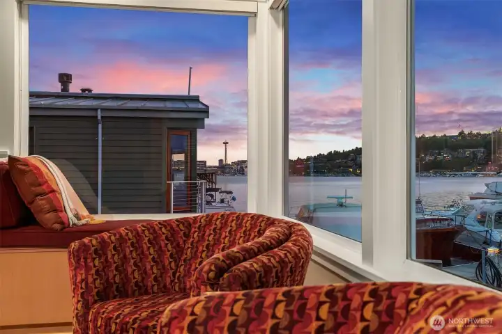 From the window seat, the Space Needle and Queen Anne lights come up under a streaky pink sky — a nightly, free show.