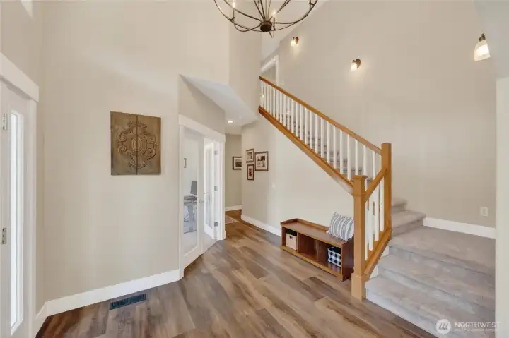 Light and bright two-story entry.  French doors on left lead to main floor office.  Hall leads to family room, powder bath, utility room and oversized three car garage.
